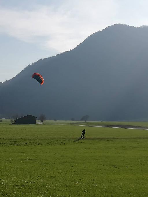 kiter auf wiese vor bergen